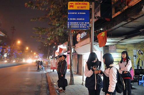 Một số em học sinh trường Kim Liên chờ xe buýt về nhà lúc 19h15 khi phố Phạm Ngọc Thạch khá vắng vẻ.